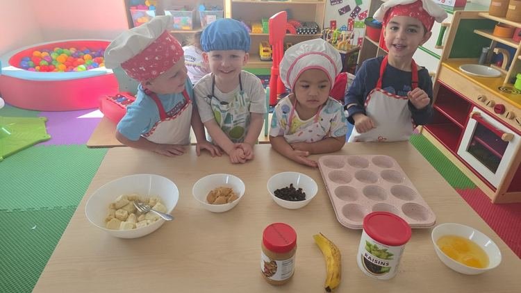 Children in chef hats preparing a healthy snack