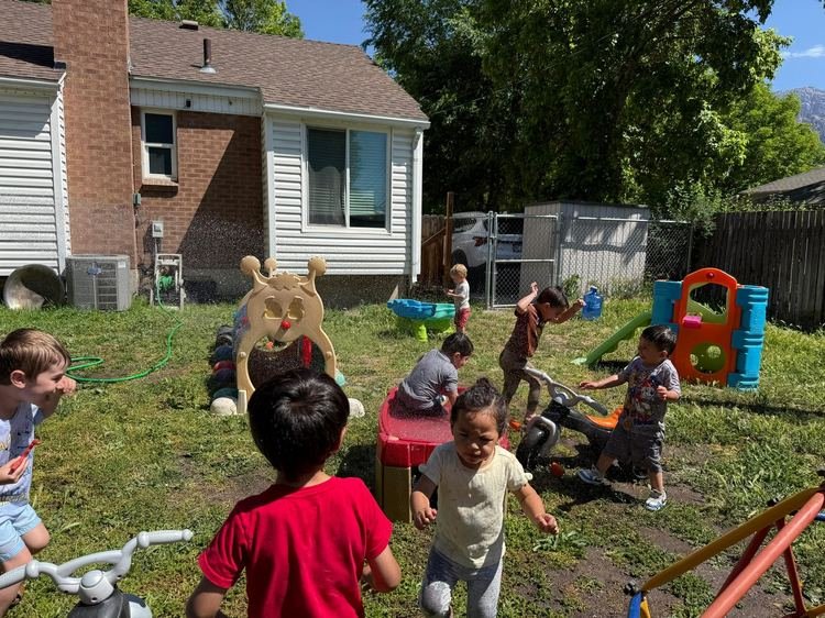 Children playing in the backyard sprinkler