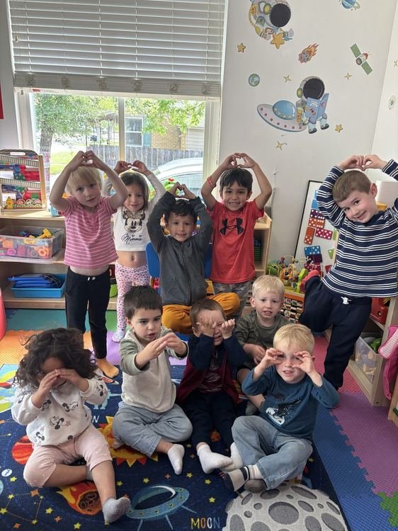 Children making heart shapes with their hands