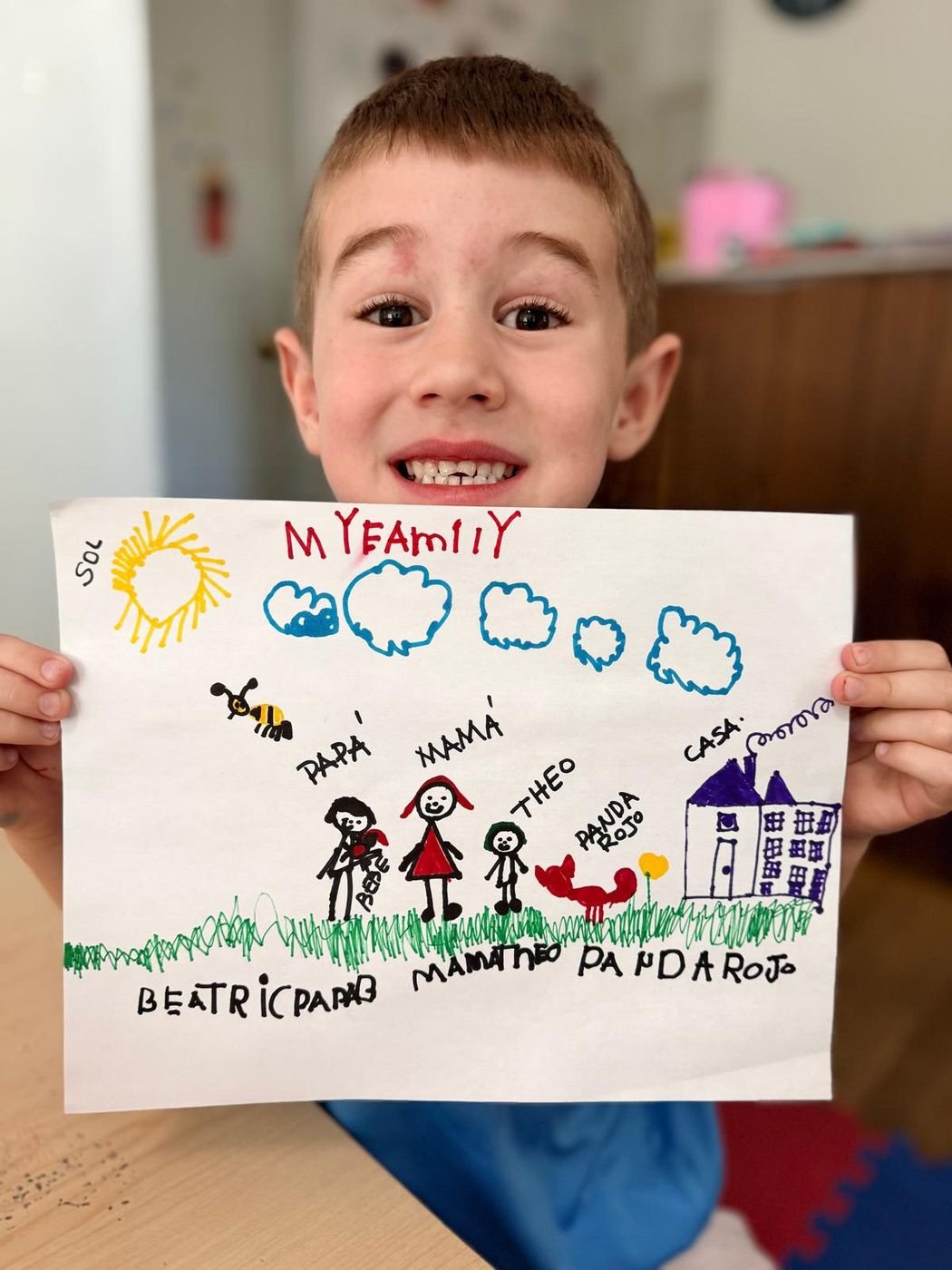 A boy smiling with his family drawing at Aby Early Learning Center